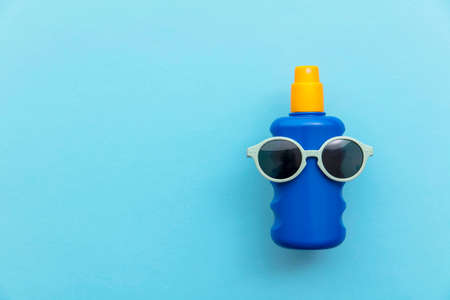 Summer holiday vacation background. Bottle of sun cream with sunglassesの写真素材