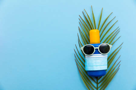 virus summer vacation background. Sun cream with sunglasses and face maskの写真素材