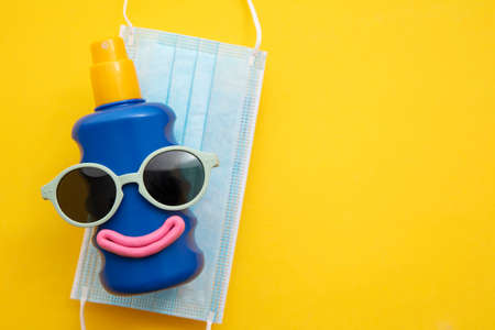 summer background. Sun cream face with sunglasses and face maskの写真素材