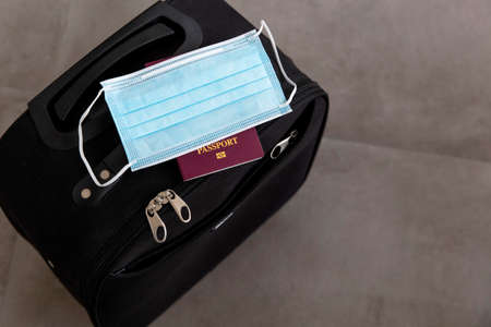 Suitcase with a protective face mask and passportの写真素材