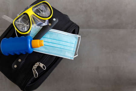 Suitcase with a face mask sun cream and scuba maskの写真素材