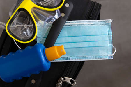 Suitcase with a face mask sun cream and scuba maskの写真素材