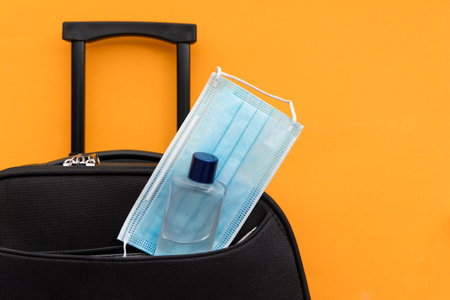 Travel suitcase packed with a face mask and hand sanitiserの写真素材