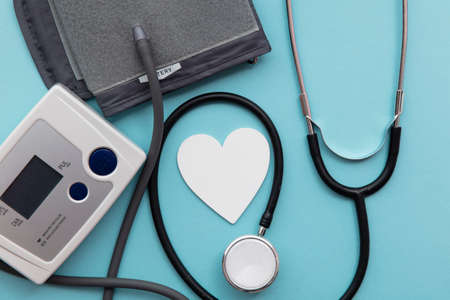 Blood pressure test monitor with a stethoscope on a blue backgroundの写真素材