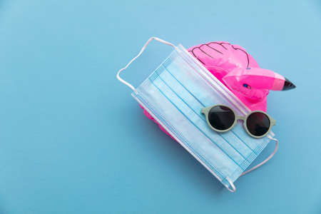 virus summer holiday background with mask sunglasses and flamingoの写真素材