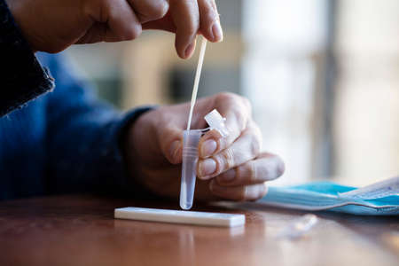 Close up of a person using coronavirus covid-19 rapid antigen home testing kitの写真素材