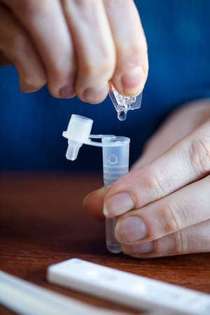 Close up of a person using coronavirus covid-19 rapid antigen home testing kitの写真素材