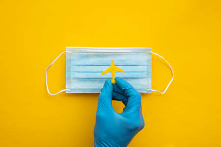vacation travel. Airplane held over a protective face maskの写真素材