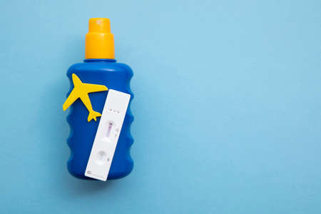 Covid lateral flow test on a bottle of suncream. Coronavirus travel concept