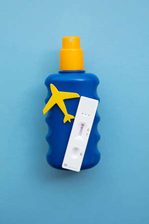 Covid lateral flow test on a bottle of suncream. Coronavirus travel concept