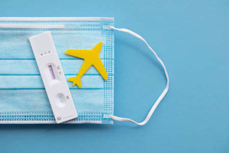 Covid travel concept. Airplane with covid19 test kit on a face maskの写真素材