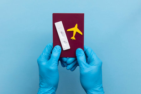 Covid19 travel passport. Person holds lateral antigen test and plane