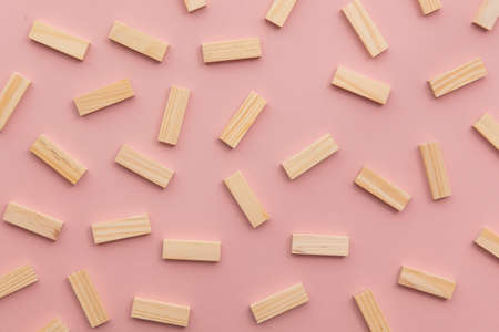 Collection of rectangular wooden blocks on a pink background. Business concept