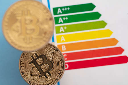 Bitcoin cryptocurrency gold coin with an energy efficiency rating chartの写真素材
