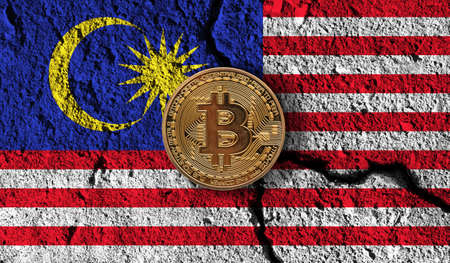 Bitcoin crypto currency coin with cracked Malaysia flag. Crypto restrictionsの写真素材