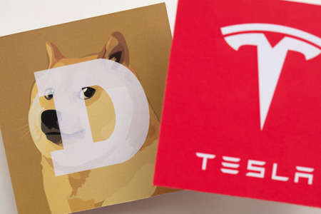 LONDON, UK - June 2021: Tesla electric vehicle and dogecoin cryptocurrencyのeditorial素材