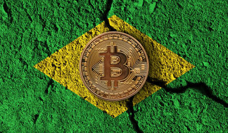 Bitcoin crypto currency coin with cracked Brazil flag. Crypto restrictionsの写真素材