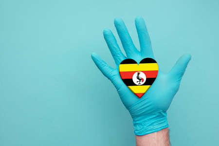 Uganda medical health heart. Nurse hand holding country heart flagの写真素材