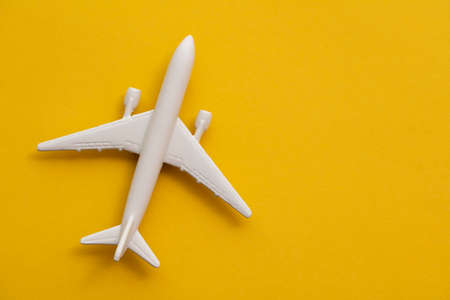 White passenger airplane on a summer yellow background. Travel and vacation backgroundの写真素材