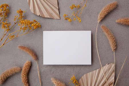 Bohemian blank invitation card surrounded by natural dried palm leaf and grasses. Wedding and...