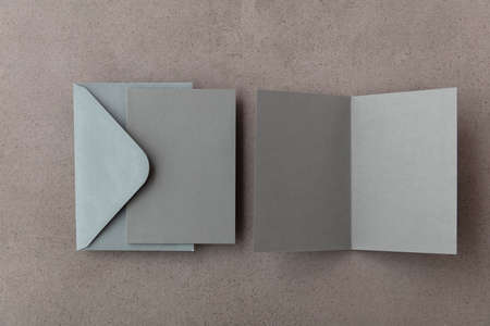 Blank grey card with grey paper envelope template mock up on a concrete background