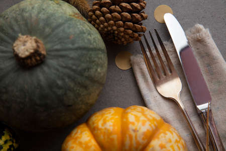 Autumn place setting lifestyle thanksgiving background with cutlery and pumpkinsの写真素材