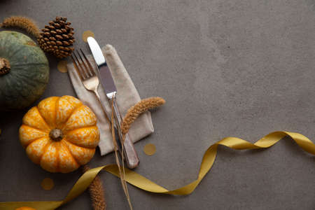 Autumn place setting lifestyle thanksgiving background with cutlery and pumpkinsの写真素材