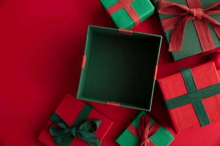 Open festive christmas present box on a red background. Flat lay, top view