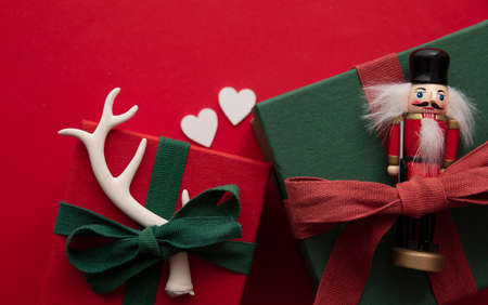 Hand made stylish Christmas gift box presents tied with red ribbon and a festive reindeer antler and...