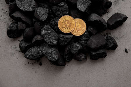 Bitcoin mining concept. Gold bitcoin cryptocurrency coin in a pile of coalの写真素材