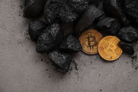 Bitcoin mining concept. Gold bitcoin cryptocurrency coin in a pile of coalの写真素材