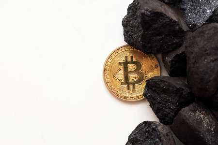 Bitcoin mining concept. Gold bitcoin cryptocurrency coin with lumps of coalの写真素材