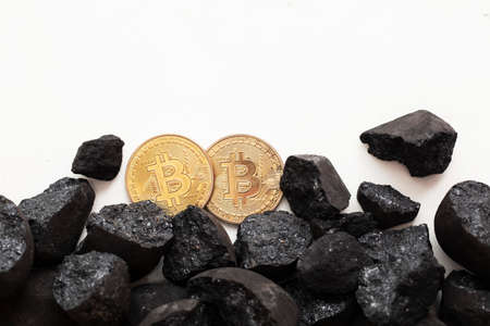 Bitcoin mining concept. Gold bitcoin cryptocurrency coin with lumps of coalの写真素材