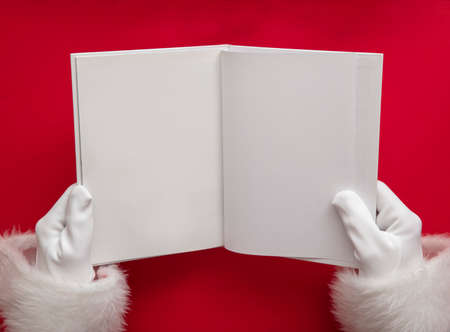 Santa claus holding a book with blank pages. Christmas book mockupの写真素材