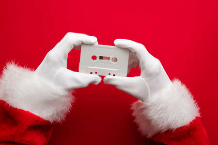 Father Christmas holding a retro music cassette tape. Christmas party conceptの写真素材