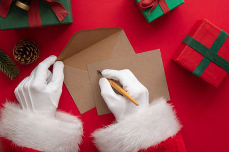 Santa Claus wiring a festive message on blank paperの写真素材