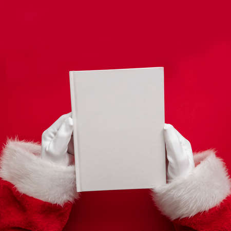 Santa claus holding a book with blank pages. Christmas book mockupの写真素材