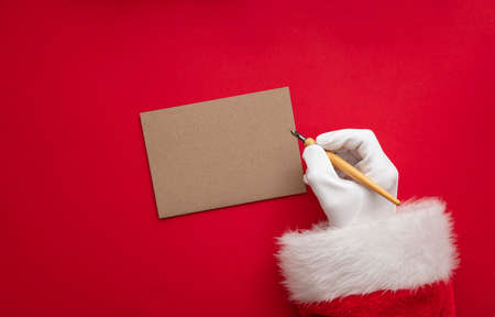 Santa Claus wiring a festive message on blank paperの写真素材
