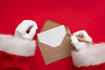 Santa Claus wiring a festive message on blank paperの写真素材