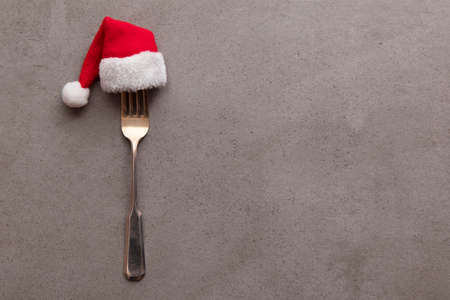 Christmas food background. Fork utensil wearing a festive father Christmas hatの写真素材