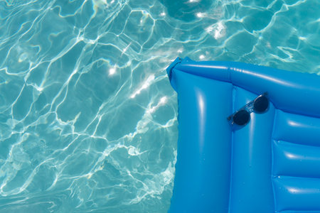 Sunglasses on a blue swimming pool float. Summer holiday backgroundの写真素材