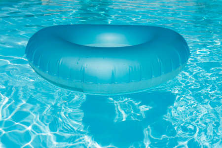 Blue summer pool rubber ring floating on a vacation swimming poolの写真素材