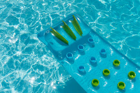 Clear blue summer pool lounger float on a rippled swimming pool