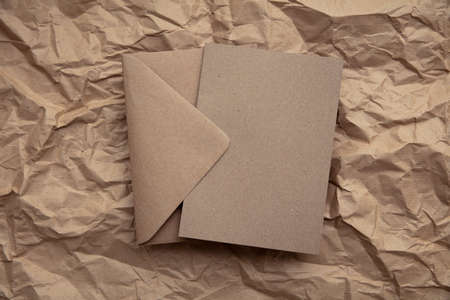 Blank card with kraft brown paper envelope template mock up on crumpled brown paperの写真素材