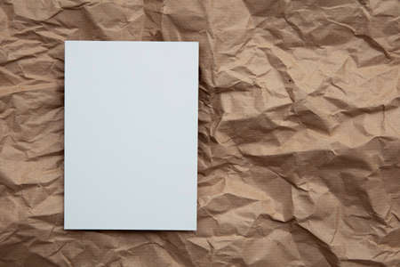 Blank white invitation letter template mock up on crumpled brown paperの写真素材
