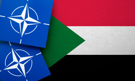 LONDON, UK - August 2022: NATO North Atlantic Treaty Organization military alliance logo on a Sudan flagのeditorial素材