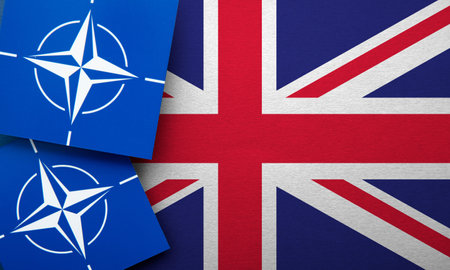 LONDON, UK - August 2022: NATO North Atlantic Treaty Organization military alliance logo on a United Kingdom flagのeditorial素材