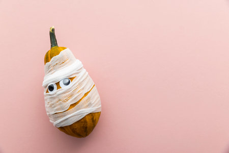 Hallowwen holiday background concept. Gourd pumpkins dressed as scary mummies with bandages and eyesの写真素材