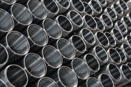Pattern of metal cylinders stand on table at factory. Steel products to automotive industry. Billet obtained on lathe from steel and cast iron. Circular precision steel parts arranged in rowsの写真素材