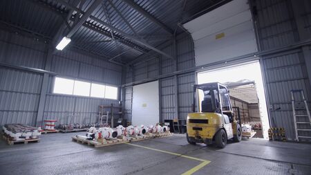 Teamwork male person industry production, using machine work and vehicle, delivering merchandise for transnational export. Loading Oil Wellhead tree equipment on pallets into truck in warehouseの写真素材